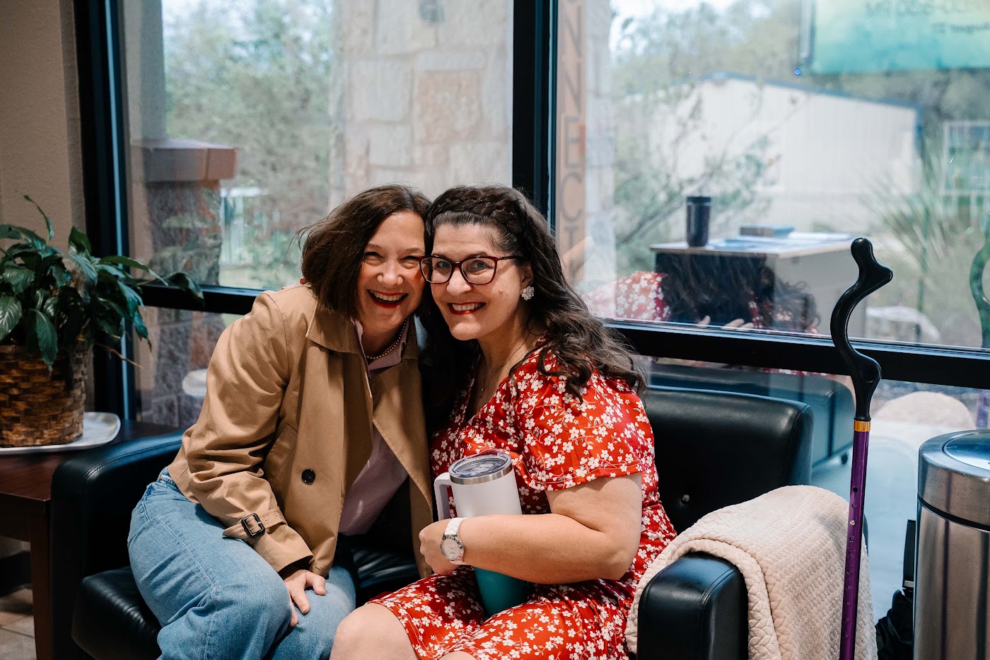 Two women laughing together in the Christ Community Church lobby